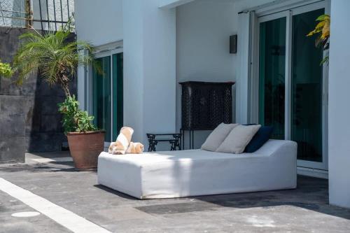 a white couch sitting outside of a building at Casa Coco - 4BR | Private Pool | Hotel Zone in Cancún