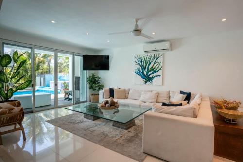 a living room with a white couch and a glass table at Casa Coco - 4BR | Private Pool | Hotel Zone in Cancún