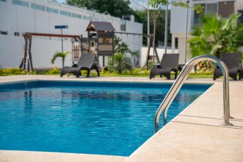 a swimming pool with two chairs and a slide at 3BR Modern House - Central & Fully Equipped in Cancún