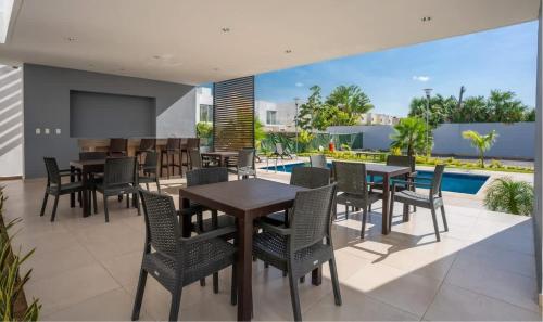 a patio with tables and chairs and a television at 3BR Modern House - Central & Fully Equipped in Cancún