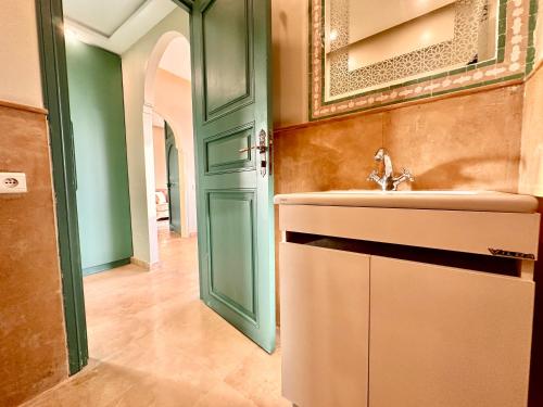 een badkamer met een wastafel en een groene deur bij Chanel in Marrakesh