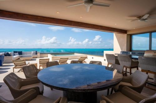 a room with a table and chairs and a view of the ocean at 5BR Luxury Beachfront Penthouse w/ Private Pool in Isla Mujeres