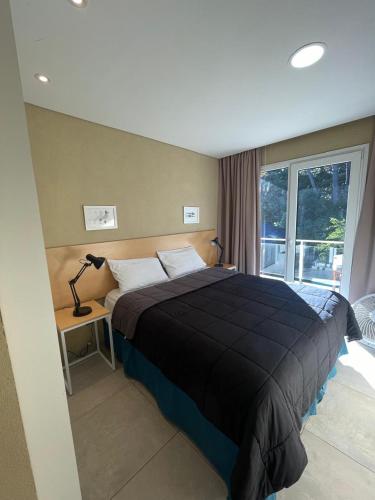 a bedroom with a large bed and a window at Nexo Playa Depto 6 in Valeria del Mar