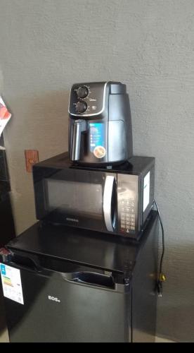 a coffee maker is sitting on top of a microwave at Chalé vista linda DM pedra azul in Domingos Martins