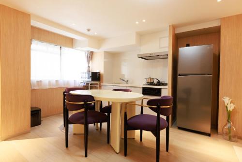 a kitchen with a table and chairs and a refrigerator at MKG Home・芝 in Tokyo