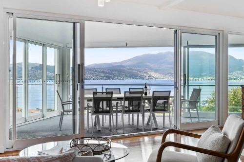 - un salon avec une table et une vue sur l'océan dans l'établissement Hillside Hideaway Sleeps 10 Stunning Views, à Howrah