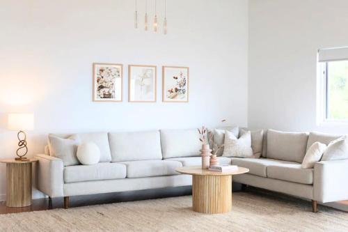 a living room with a white couch and a table at Hillside Hideaway Sleeps 10 Stunning Views in Howrah