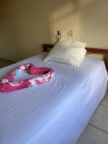 a white bed with a blanket on top of it at Quarto Econômico no Centro para 2 Pessoas in Sete Lagoas