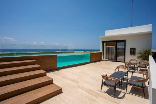 a house with a swimming pool and some chairs at 2BR Condo w/ Rooftop Oceanview & Centric Location in Playa del Carmen