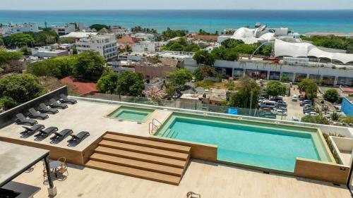 a pool on the roof of a building with a view at 2BR Condo w/ Rooftop Oceanview & Centric Location in Playa del Carmen