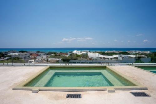 a swimming pool with a view of the ocean at 2BR Condo w/ Rooftop Oceanview & Centric Location in Playa del Carmen