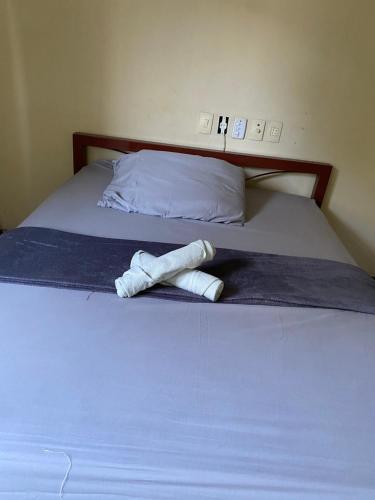 a pair of towels sitting on a bed at Quarto Econômico no Centro para 2 Pessoas in Sete Lagoas
