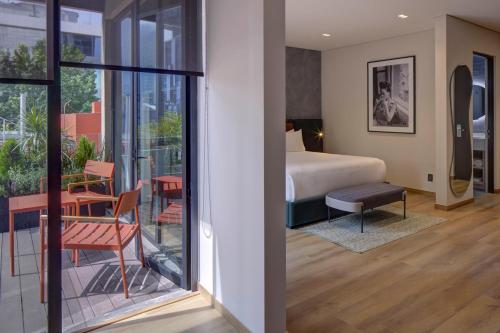 a hotel room with a bed and a balcony at Ubicuo Hotel Boutique in Mexico City