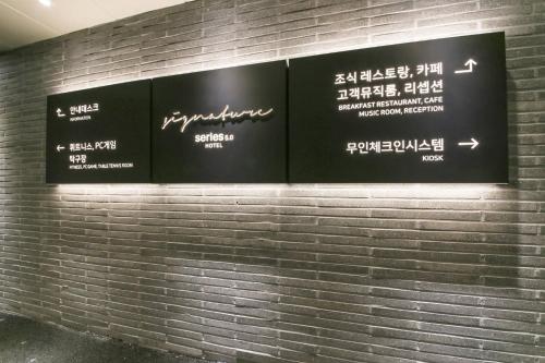 a sign on a brick wall with writing on it at Daegu Seongseo Hotel Series 5.0 in Daegu