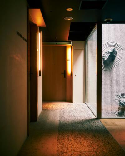 an empty hallway with a door and a window at hotel androoms Kyoto Shichijo in Kyoto
