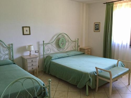 a bedroom with two beds and a chair and a window at Il Girasole in Venturina Terme