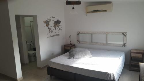 une chambre blanche avec un lit et une fenêtre dans l'établissement La Ponderosa, à Veinticinco de Mayo