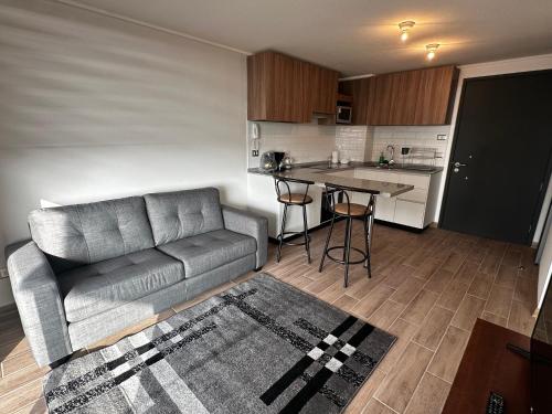 a living room with a couch and a kitchen at Departamento 1 ambiente in Antofagasta