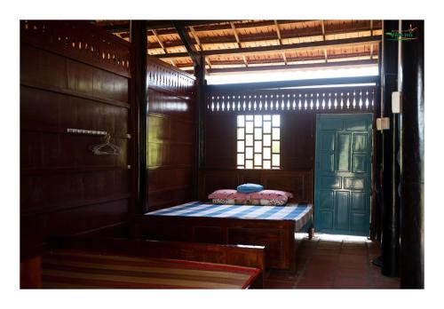 una piccola camera con panchina e porta di Nông Trại Hải Vân - Sân Chim Vàm Hồ a Ben Tre