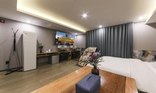 a living room with a couch and a desk and a tv at Daegu Seongseo Hotel Series 5.0 in Daegu