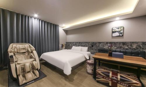 a bedroom with a bed and a couch and a table at Daegu Seongseo Hotel Series 5.0 in Daegu