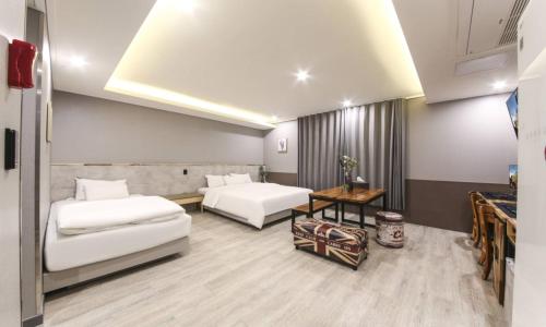 a hotel room with two beds and a table at Daegu Seongseo Hotel Series 5.0 in Daegu