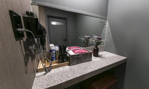 a bathroom counter with a sink and a mirror at Daegu Seongseo Hotel Series 5.0 in Daegu
