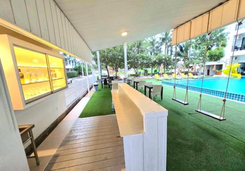 a building with a bench next to a swimming pool at The Regizt Jomtien Pattaya in Jomtien Beach