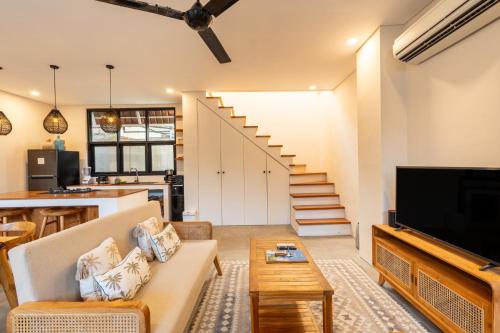 a living room with a couch and a tv at Hati Villa by Betterplace in Canggu