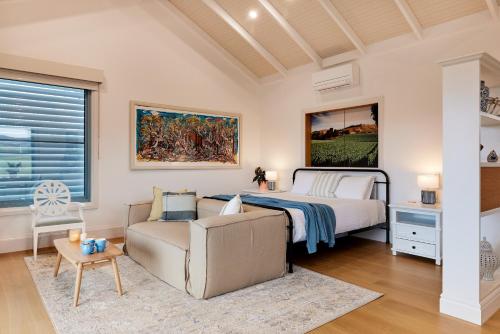 a bedroom with a bed and a couch at Soumah of Yarra Valley in Gruyere