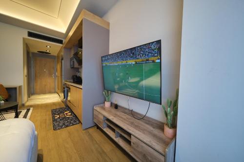 a living room with a large flat screen tv on a wall at The Diamond In City Luxury Suites By ZENORA Living in Accra