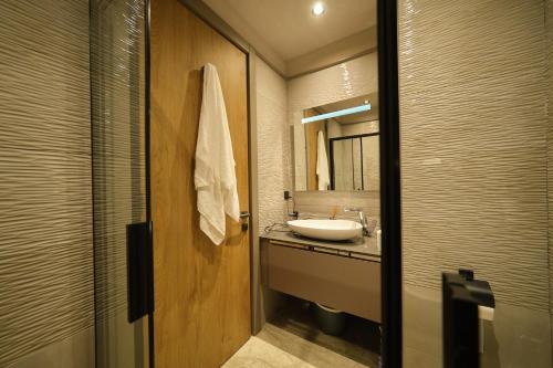 a bathroom with a sink and a mirror at The Diamond In City Luxury Suites By ZENORA Living in Accra