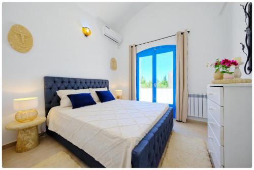 a bedroom with a bed and a door to a patio at Dar zeytouna in Hammamet