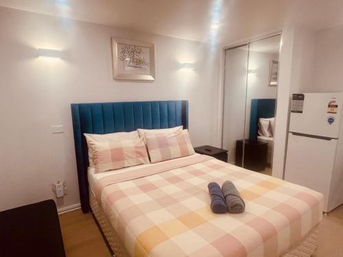 a bed with two pairs of shoes sitting on it at Cosy Homes - 15 Minutes Away From Melbourne Airport in St Albans