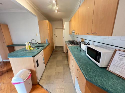 a kitchen with a green counter top and a microwave at Comfortable Queen Room close to Station and Shops - SH4 in Toongabbie West
