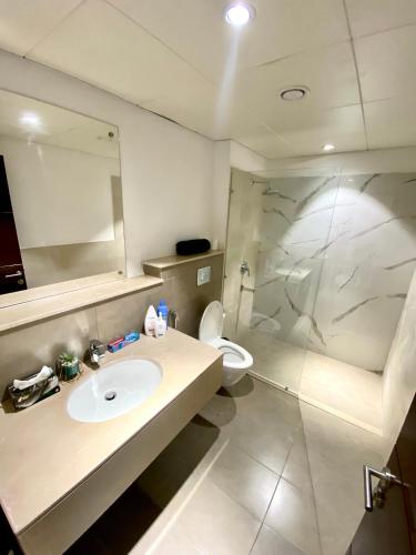 a bathroom with a sink and a toilet and a mirror at One Constitution Avenue by SUPERHOST STAYS in Islamabad