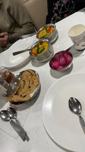 a table with plates and bowls of food on it at Al Hayat Guest House in Pahalgām