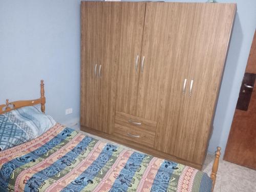 a bedroom with a wooden cabinet next to a bed at Casa Marcelo in Salta