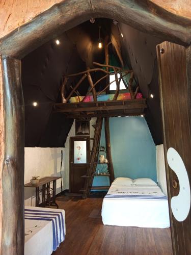 an attic room with two bunk beds and a table at Sigiri Hunter's Eco Tree lodge in Sigiriya