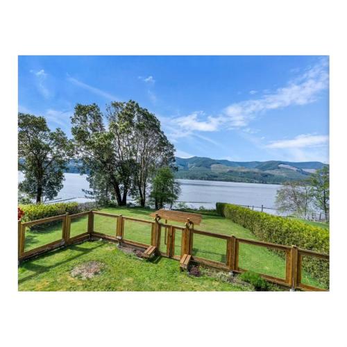 a wooden fence with a view of a lake at Youbou Lake Front Getaway in Youbou