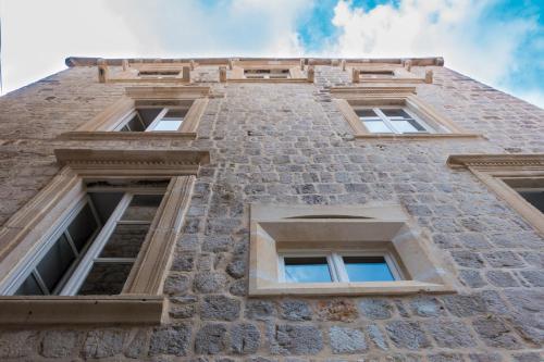 a tall brick building with four windows at Dominus Little Palace in Dubrovnik