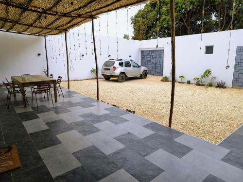 a patio with a table and chairs and a car at Villa Chérifa in Guéréo