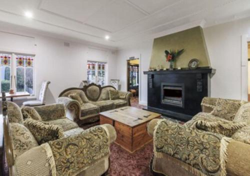 a living room with couches and a fireplace at Hotel Blue & Cottages Katoomba in Katoomba