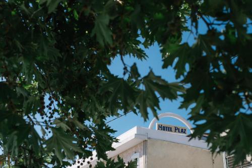a sign on the top of a building with trees at Plaz Hotel in Selianitika