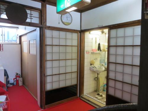 a small bathroom with a toilet and a sink at Komecho Ryokan in Imabari