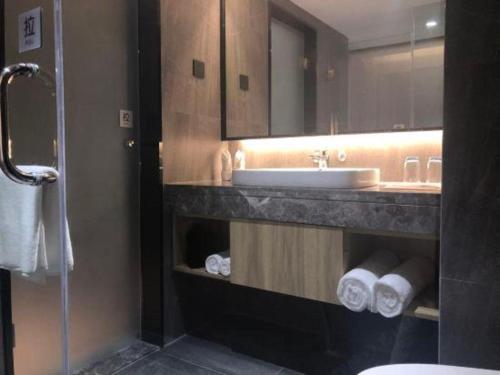 a bathroom with a sink and a mirror at danfeng kelly hotel in Shenzhen