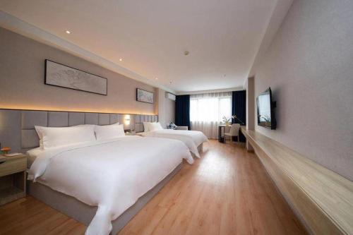 a large hotel room with two beds and a television at danfeng kelly hotel in Shenzhen