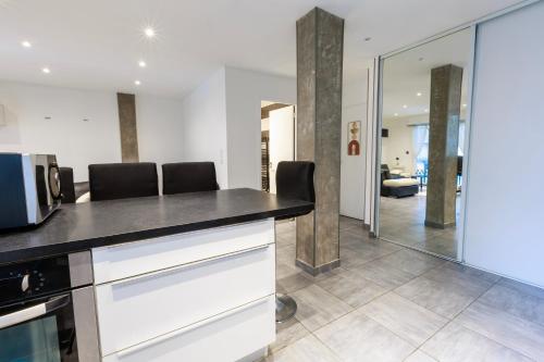 a kitchen with a counter top and a living room at Family Flat Cannes Centre in Cannes
