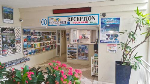 a grocery store with a reception sign and flowers at Macrossan House Boutique Holiday Apartments in Port Douglas
