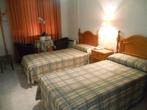 pokój hotelowy z 2 łóżkami i stołem w obiekcie Hotel Paris w mieście Lanjarón